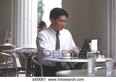 Male executive working on laptop computer in cafe View Large Photo Image Stock Image - Male executive working on laptop computer in cafe. Fotosearch
