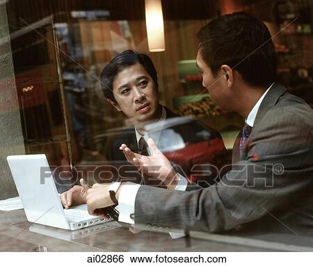 Male executives using laptop and talking, seen through glass window. View Large Photo Image Stock Photograph - Male executives using laptop and talking, seen through glass window.. Fotosearch