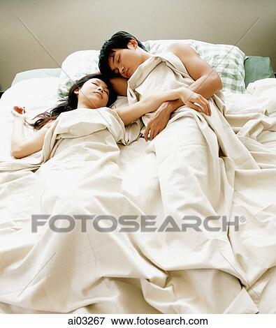 Stock Photo - Man and woman in bed, under sheet. Fotosearch