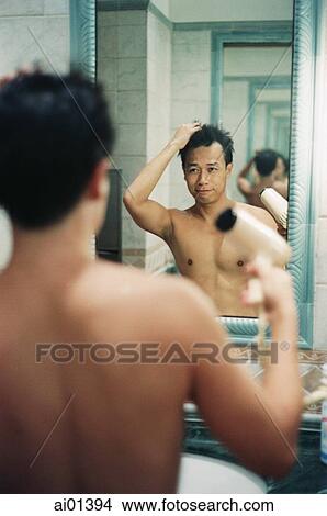 Man blow drying hair reflected in mirror View Large Photo Image Picture - Man blow drying hair reflected in mirror. Fotosearch