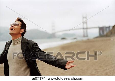 Man by beach, arms outstretched View Large Photo Image Picture - Man by beach, arms outstretched. Fotosearch