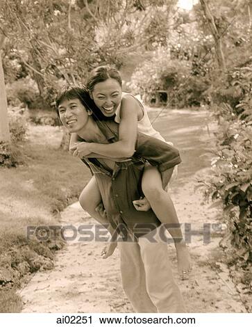 Man carries woman on back, laughing View Large Photo Image Stock Image - Man carries woman on back, laughing. Fotosearch