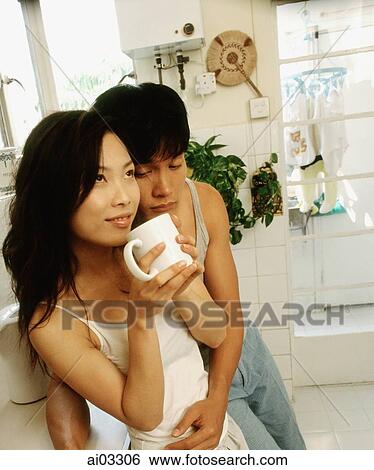 Man embracing woman in kitchen View Large Photo Image Stock Photograph - Man embracing woman in kitchen. Fotosearch