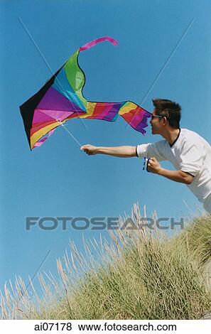 Man flying kite View Large Photo Image Stock Photo - Man flying kite. Fotosearch