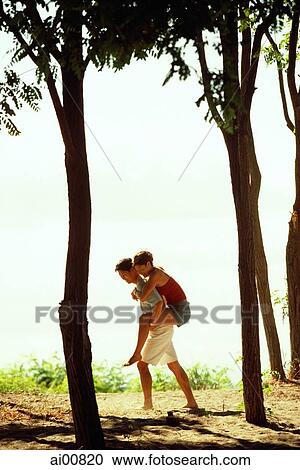 Man giving woman a piggyback ride amongst trees View Large Photo Image Stock Image - Man giving woman a piggyback ride amongst trees. Fotosearch