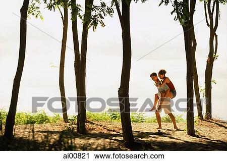 Man giving woman a piggyback ride amongst trees, by the beach View Large Photo Image Stock Image - Man giving woman a piggyback ride amongst trees, by the beach. Fotosearch
