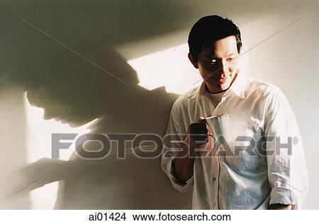Man holding coffee cup looking down View Large Photo Image Picture - Man holding coffee cup looking down. Fotosearch