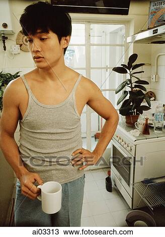 Man holding cup, kitchen in background View Large Photo Image Stock Image - Man holding cup, kitchen in background. Fotosearch