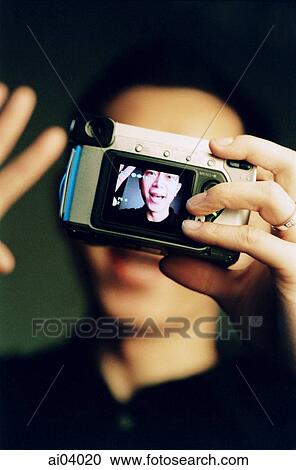 Man holding digital camera, black background ( high grain) View Large Photo Image Stock Image - Man holding digital camera, black background ( high grain). Fotosearch
