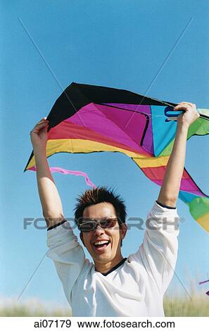 Man holding kite ( high grain) View Large Photo Image Stock Photo - Man holding kite ( high grain). Fotosearch