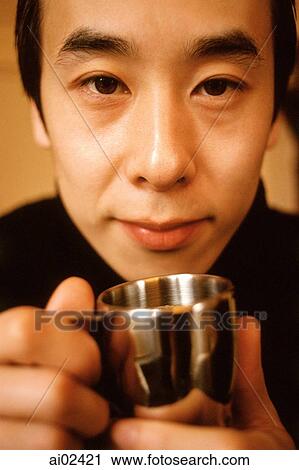 Stock Image - Man holding silver cup, portrait.. Fotosearch