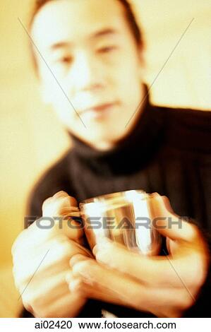 Stock Image - Man holding silver cup.. Fotosearch