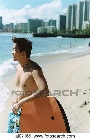 Man leaning on wakeboard by beach ( high grain) View Large Photo Image Stock Photography - Man leaning on wakeboard by beach ( high grain). Fotosearch