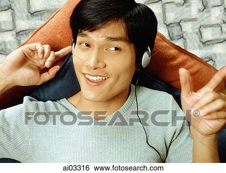 Man listening to headphones View Large Photo Image Stock Photograph - Man listening to headphones. Fotosearch