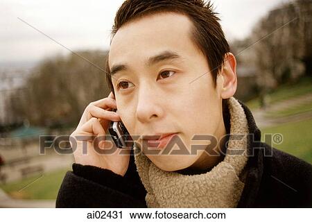 Stock Image - Man outdoors using cellular phone.. Fotosearch