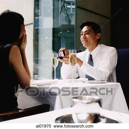Man proposing to woman in restaurant with engagement ring View Large Photo Image Stock Image - Man proposing to woman in restaurant with engagement ring. Fotosearch