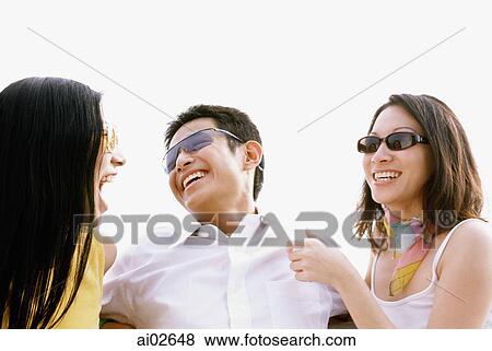 Man sitting between two woman, laughing, outdoors View Large Photo Image Stock Photo - Man sitting between two woman, laughing, outdoors. Fotosearch