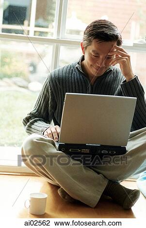 Man sitting cross-legged using laptop View Large Photo Image Stock Image - Man sitting cross-legged using laptop. Fotosearch