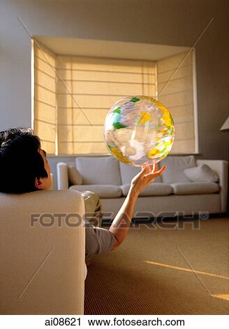 Man sitting, holding plastic globe with one hand, back view. View Large Photo Image Stock Image - Man sitting, holding plastic globe with one hand, back view.. Fotosearch