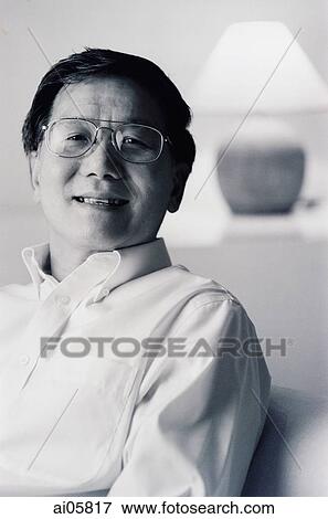 Man sitting in living room, portrait View Large Photo Image Stock Photo - Man sitting in living room, portrait. Fotosearch