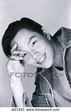 Stock Image - Man smiling, with hand on forehead, portrait ( high grain). Fotosearch