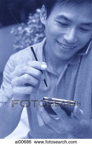 Man talking on cellular phone holding palmtop View Large Photo Image Stock Photograph - Man talking on cellular phone holding palmtop. Fotosearch