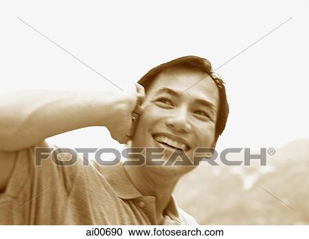 Stock Image - Man talking on cellular phone, smiling. Fotosearch