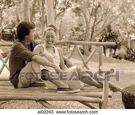 Man talking with woman on bench outdoors View Large Photo Image Stock Image - Man talking with woman on bench outdoors. Fotosearch