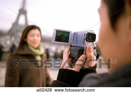 Man videotaping woman in front of Eiffel Tower, focus on camcorder. View Large Photo Image Stock Photo - Man videotaping woman in front of Eiffel Tower, focus on camcorder.. Fotosearch