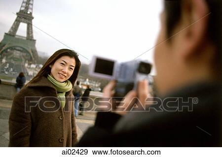 Man videotaping woman in front of Eiffel Tower, focus on woman. View Large Photo Image Stock Photo - Man videotaping woman in front of Eiffel Tower, focus on woman.. Fotosearch