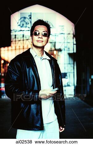 Man wearing sunglasses, holding cellular phone View Large Photo Image Stock Photo - Man wearing sunglasses, holding cellular phone. Fotosearch
