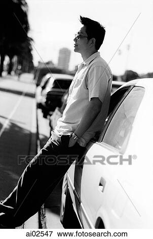 Man wearing sunglasses leaning on car View Large Photo Image Stock Photo - Man wearing sunglasses leaning on car. Fotosearch