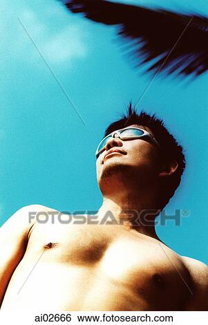 Man wearing sunglasses, low view, blue sky in background View Large Photo Image Stock Photograph - Man wearing sunglasses, low view, blue sky in background. Fotosearch