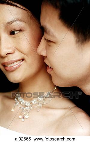 Man whispering into woman's ear View Large Photo Image Stock Photography - Man whispering into woman's ear. Fotosearch