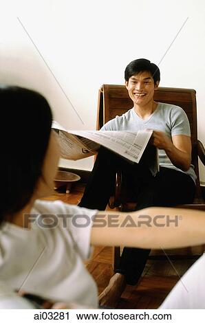 Stock Image - Man with newspaper talking with woman. Fotosearch