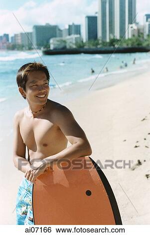 Man with wakeboard by beach, smiling ( high grain) View Large Photo Image Stock Photograph - Man with wakeboard by beach, smiling ( high grain). Fotosearch