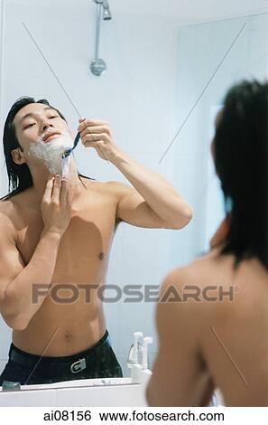 Mirror reflection of young man shaving in bathroom. View Large Photo Image Stock Photograph - Mirror reflection of young man shaving in bathroom.. Fotosearch