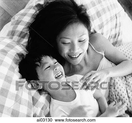 Mother and son playing in bed, laughing View Large Photo Image Stock Image - Mother and son playing in bed, laughing. Fotosearch