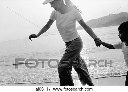 Mother and son walking on beach View Large Photo Image Stock Photo - Mother and son walking on beach. Fotosearch