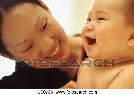 Mother looking at baby boy (3-9 months old) laughing View Large Photo Image Stock Photograph - Mother looking at baby boy (3-9 months old) laughing. Fotosearch