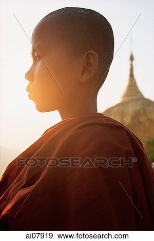 Stock Photo - Myanmar (Burma), Bago, Kyaityo, Novice monk in front of hanging rock pagoda, profile. (grainy). Fotosearch