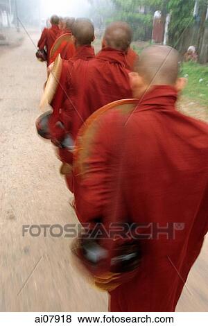 Stock Photo - Myanmar (Burma), Bago, Novice monks collect alms early in the morning. (grainy). Fotosearch