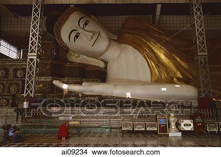 Myanmar (Burma), Bago, Shwethalyaung, Buddhist monk prays in front of reclining Buddha. View Large Photo Image Picture - Myanmar (Burma), Bago, Shwethalyaung, Buddhist monk prays in front of reclining Buddha.. Fotosearch