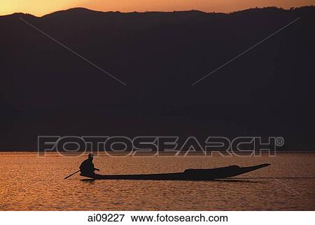 Myanmar (Burma), Inle lake, Silhouette of fisherman in canoe at sunrise. View Large Photo Image Stock Photo - Myanmar (Burma), Inle lake, Silhouette of fisherman in canoe at sunrise.. Fotosearch
