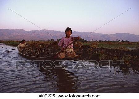 Myanmar (Burma), Inle lake, Women steering canoe filled with firewood. View Large Photo Image Stock Photography - Myanmar (Burma), Inle lake, Women steering canoe filled with firewood.. Fotosearch