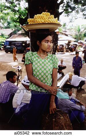 Myanmar (Burma), Yangon (Rangoon), A vendor balancing a platter of fruit on her head in a market in Yangon. View Large Photo Image Stock Image - Myanmar (Burma), Yangon (Rangoon), A vendor balancing a platter of fruit on her head in a market in Yangon.. Fotosearch