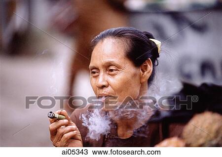 Myanmar (Burma), Yangon (Rangoon), A Burmese woman smoking a homegrown, hand-rolled cigarette called a "cheroot". View Large Photo Image Stock Image - Myanmar (Burma), Yangon (Rangoon), A Burmese woman smoking a homegrown, hand-rolled cigarette called a "cheroot".. Fotosearch