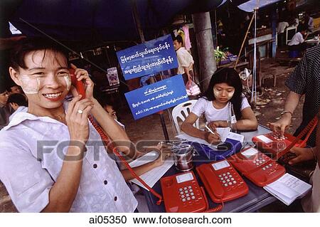 Myanmar (Burma), Yangon (Rangoon), A woman wearing homemade makeup makes a telephone call at an open-air public phone station. View Large Photo Image Stock Image - Myanmar (Burma), Yangon (Rangoon), A woman wearing homemade makeup makes a telephone call at an open-air public phone station.. Fotosearch