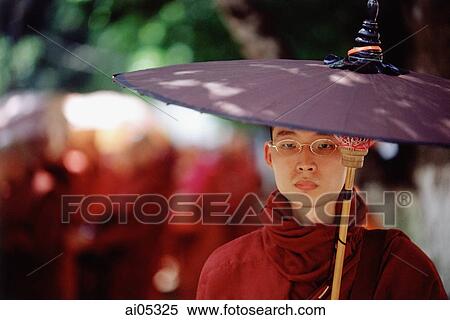 Myanmar (Burma), Yangon (Rangoon), A Buddhist monk walking with an umbrella on a sunny day. View Large Photo Image Stock Photography - Myanmar (Burma), Yangon (Rangoon), A Buddhist monk walking with an umbrella on a sunny day.. Fotosearch