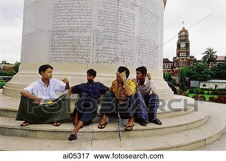 Myanmar (Burma), Yangon (Rangoon), Young men sitting at the base of the Independence Monument in Yangon. View Large Photo Image Stock Photo - Myanmar (Burma), Yangon (Rangoon), Young men sitting at the base of the Independence Monument in Yangon.. Fotosearch